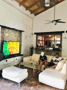 two people sitting on a couch in a living room at Casa Mamá Waldy Hostel in Cartagena de Indias