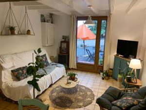 ein Wohnzimmer mit einem Sofa und einem Tisch in der Unterkunft Chez Mima in Samadet