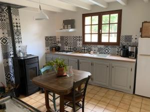 eine Küche mit einem Holztisch und einem Kühlschrank in der Unterkunft Chez Mima in Samadet
