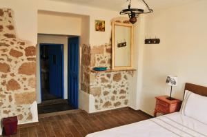 a bedroom with a bed and a blue door at Alterna Köy Evi in Sokakagzi