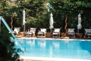 
a pool with chairs and umbrellas in it at Sea View Hotel in Athens
