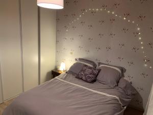 a bedroom with a bed with lights on the wall at Chez Mima in Samadet +17 photos
