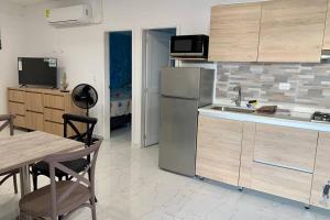 a kitchen with a sink and a refrigerator and a table at Apartamentos CC San Andres cerca a la playa in San Andrés