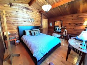 a bedroom with a bed in a log cabin at Gîte le 308 Chambre bord de l'eau oka in Oka +14 photos
