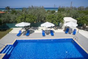 a swimming pool with chairs and umbrellas at Rafaella Beach Villa- Pvt Pool-Near Sea/Beach in Argaka
