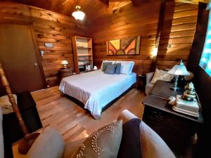 a bedroom with a bed in a log cabin at Gîte le 308 Chambre bord de l'eau oka in Oka
