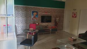 a living room with a flat screen tv on a wall at Aimé Anaïs in Abaga
