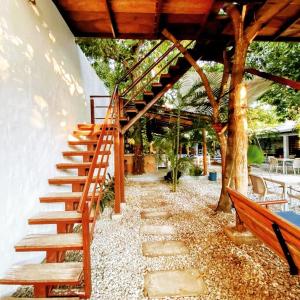 a wooden staircase next to a tree with a bench at La Casona de Sara in Honda