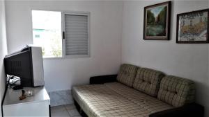 a living room with a couch and a television at Casa na praia da Pinheira in Palhoça