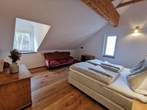- une chambre avec un lit et un canapé rouge dans l'établissement Die Alte Bäckerei, à Bescheid