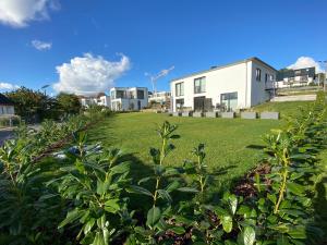 een grasveld met een huis en wat struiken bij Ferienwohnung am Kleinbahnhof in Binz