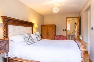 a bedroom with a large white bed with a wooden headboard at Stoney Moat in Shrewsbury