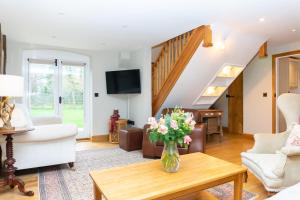 a living room with a vase of flowers on a coffee table at Stoney Moat in Shrewsbury