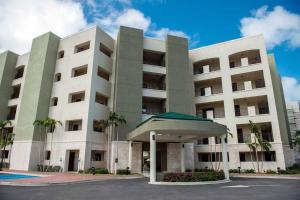 パーム・イーグル・ビーチにある112: 1-Bedroom Grd floor condo w/patio. Palm Beachのヤシの木が前に立つ大きな白い建物