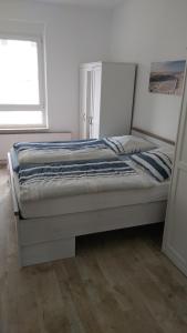 a white bed in a room with a window at Haus Kleeblatt in Borkum