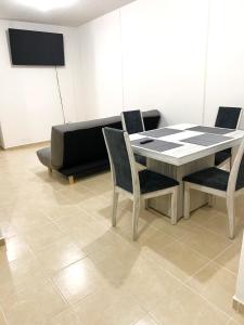 a table and chairs in a room with a couch at Hogar Cálido y Acogedor in León