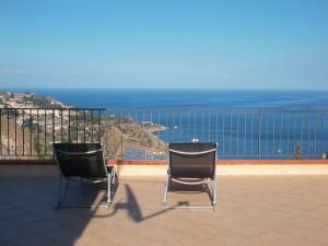 two chairs sitting on a balcony looking at the ocean at Casa Mathea in Taormina