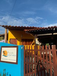 a sign in front of a house with a fence at Pousada Villa Galinhos in Galinhos