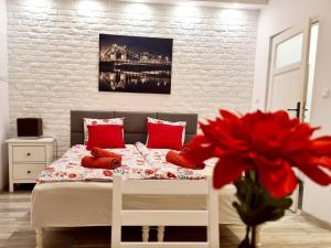 a bedroom with a bed and a vase with a red flower at Best Studio in Wrocław