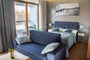 um quarto com um sofá, uma cama e uma janela em ApArt Bulwary Wrocław em Breslávia