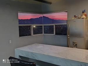 a kitchen with a refrigerator and two windows at Cerca del aeropuerto de mty y parques industriales in Monterrey