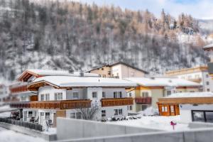 grupa budynków ze śniegiem na dachach w obiekcie Landhaus Martinus w Solden