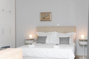 a bedroom with a white bed with two candles on it at Apartman Ružica in Pučišća