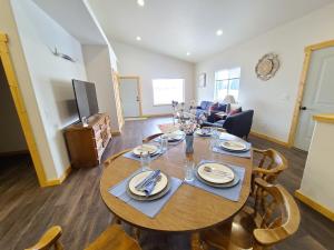 Beaverhead House Rental في ديلون: غرفة معيشة مع طاولة وكراسي خشبية