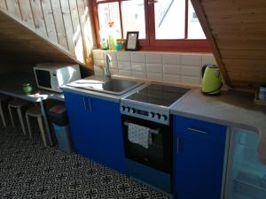 a small kitchen with a sink and a stove at Manoka Guest House in Mogyoród