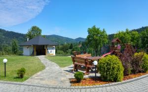 a park with a bench and a gazebo at Pokoje Gościnne Tyrol in Zawoja