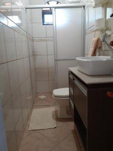 a bathroom with a toilet and a sink and a shower at Casinha do Trapiche in Penha +23 photos