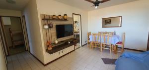 ein Wohnzimmer mit einem TV und einem Tisch mit Stühlen in der Unterkunft Excelente local in Cabo Frio