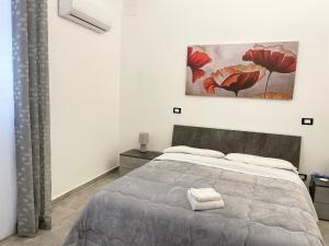 a bedroom with a bed and a painting on the wall at B&B Antichi Cortili in Termini Imerese