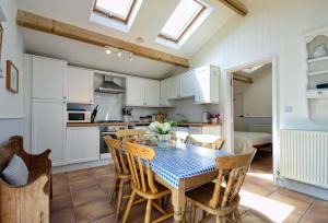 a kitchen and dining room with a table and chairs at East Green Farm Cottages - Gardeners Cottage in Saxmundham