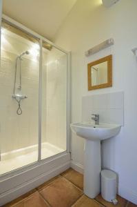 a bathroom with a sink and a shower at East Green Farm Cottages - Gardeners Cottage in Saxmundham