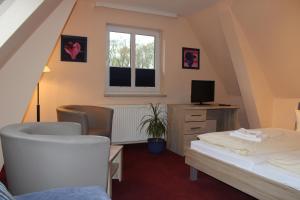 a bedroom with a bed and a desk and a window at Hotel Am Park in Pasewalk +29 photos