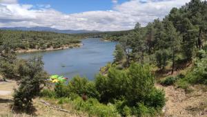 une vue d'une rivière depuis une colline avec un parapluie dans l'établissement Puente viejo de Buitrago casa Fresno, à Buitrago del Lozoya 11 autres photos