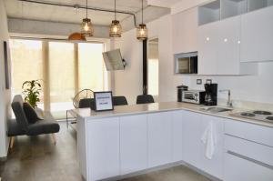 cocina con armarios blancos y encimera en Cozy Stays Cayala Apartments 4, en Guatemala