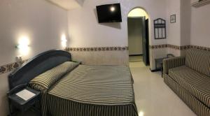 a waiting room with a couch and a tv at Casthotels Baia delle Sirene in Forio d'Ischia