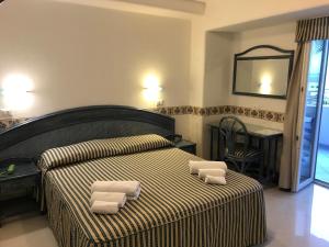 a bedroom with a bed with two towels on it at Casthotels Baia delle Sirene in Forio d'Ischia +37 photos