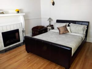 a black bed in a room with a fireplace at B&B Le Transit in Quebec City