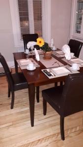 a wooden table with two chairs and a table with a flower on it at B&B Le Transit in Quebec City