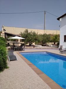 a swimming pool with a table and chairs next to a building at Cortijo Mirador de Almuñecar in Taramay