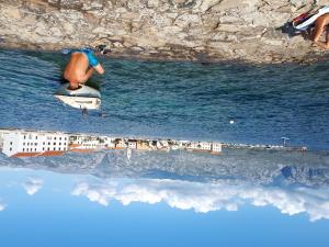 um homem sentado numa prancha de surf no oceano em Apartments in Vinjerac/Paklenica Riviera 27673 em Vinjerac