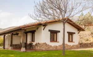 a small white house with a tree in front of it at Finca La Sayuela in El Raso