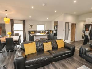 a living room with a leather couch and a kitchen at Box Tree Escapes in Lancaster