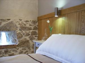 1 dormitorio con cama y pared de piedra en Maison Anderetea, en Mendionde