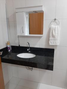 a bathroom counter with a sink and a mirror at Recanto Matheus Morotti MM in Maringá