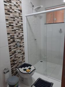 a bathroom with a toilet with a glass shower at Recanto Matheus Morotti MM in Maringá