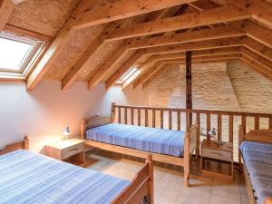 een slaapkamer op zolder met 2 bedden en een raam bij Superb holiday home with pool in Cressensac